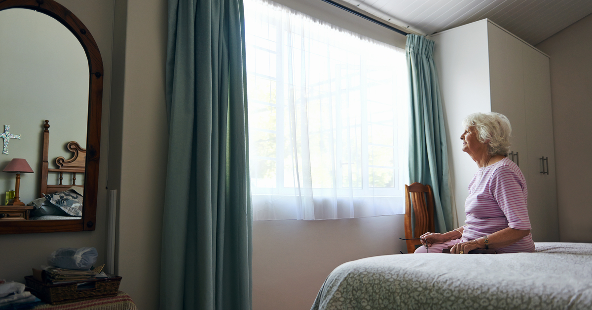 Senior Woman Listlessly Sitting on Bed