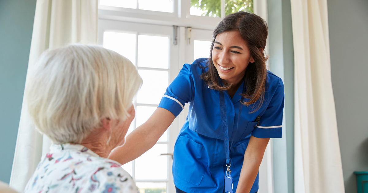 A woman enjoys her career in home health care as she cares for a senior patient in her home.