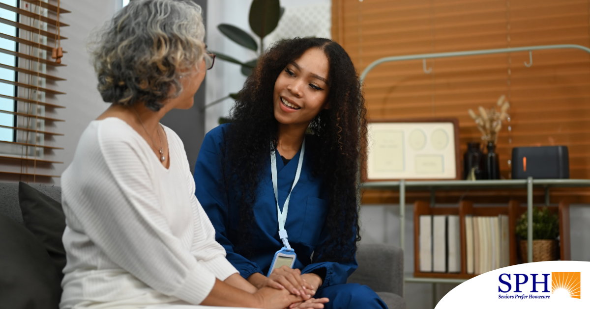 A caregiver patiently and kindly sits down and talks with a senior client, setting a good example for caregivers when it comes to communication.