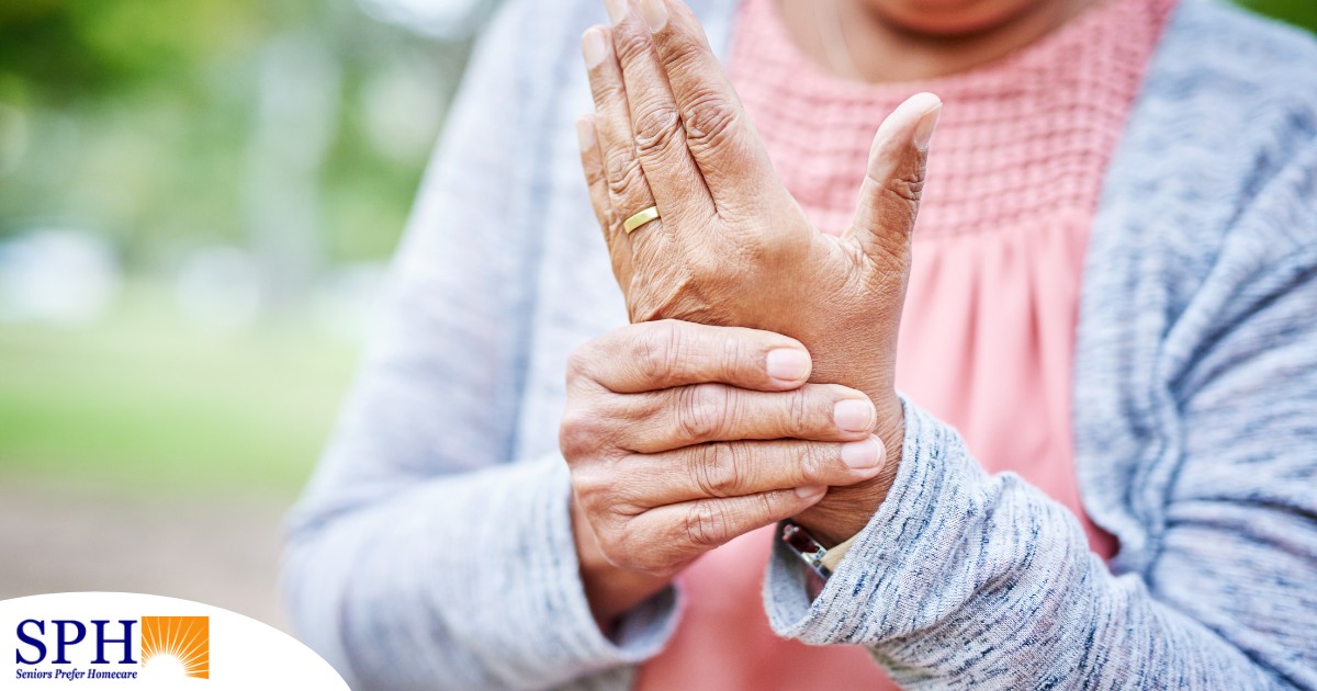 A senior woman holds her hand in pain, representing arthritis and what Arthritis Awareness Month can help with.