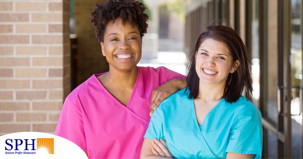 2 caregivers smile representing the good attitude that can allow home care professionals to collaborate.