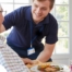 Professional caregiving involves helping clients with iADLs and ADLs as demonstrated by this caregiver helping a client by bringing a meal.
