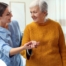 A caregiver helps a client get around, demonstrating one of the job duties of a caregiver.