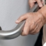 An older adult uses a grab bar representing one of the home modifications that is helpful for fall prevention for elderly adults.