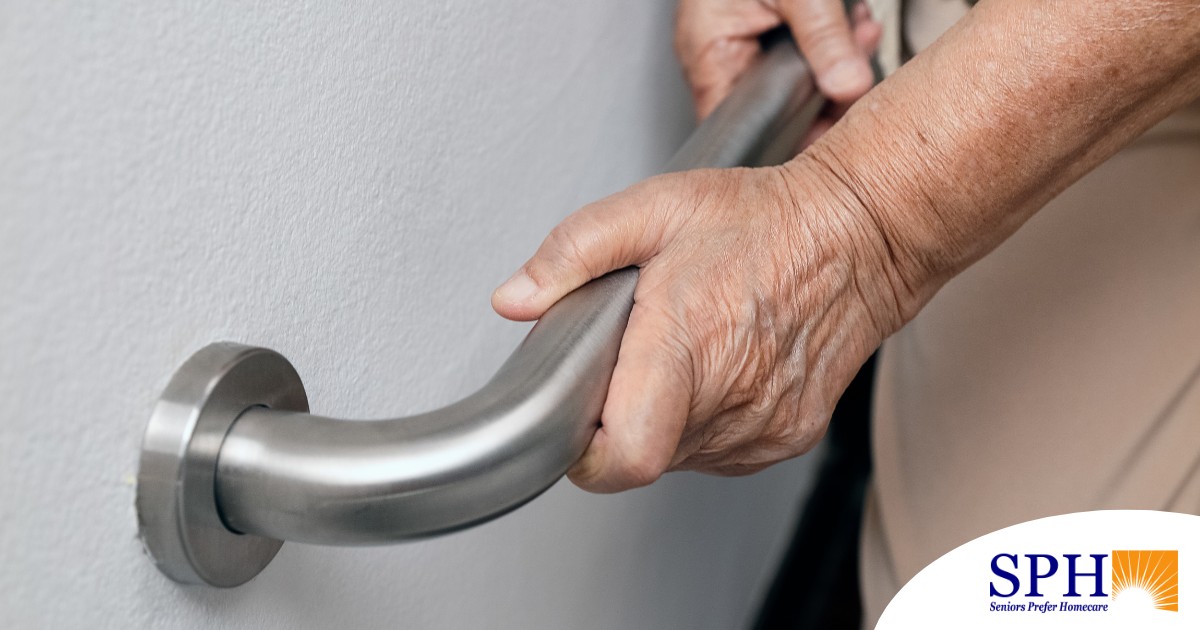 An older adult uses a grab bar representing one of the home modifications that is helpful for fall prevention for elderly adults.
