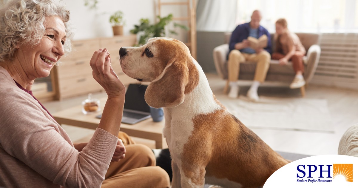 An older woman smiles while giving a dog a treat, representing the joy that dogs can bring.