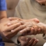 A care provider examines an older adult’s fingers, representing what would happen in an examination for rheumatoid arthritis.