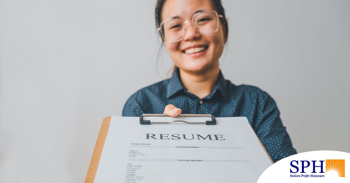 A woman happily hands in a resume, representing a successfully written caregiver resume.