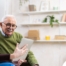 Home caregiver assisting senior man to use telehealth and senior care